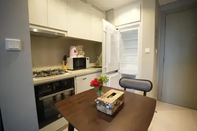 a kitchen with a wooden table with flowers on it at Joyful Journeys Downtown And Burj View Residence Business Bay One-Bedroom Apartment in Dubai