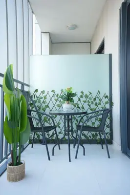 a table and chairs on a balcony with a plant at Joyful Journeys Downtown And Burj View Residence Business Bay One-Bedroom Apartment in Dubai