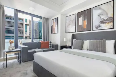a bedroom with a large white bed and a couch at Frank Porter - Goldcrest Views 2 in Dubai