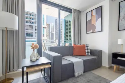 a living room with a couch and a large window at Frank Porter - Goldcrest Views 2 in Dubai