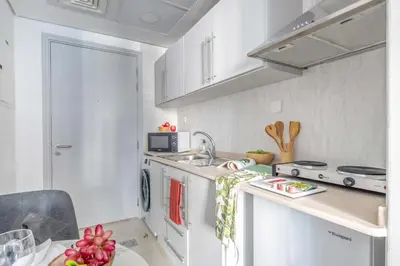 a kitchen with white cabinets and a sink at Frank Porter - Goldcrest Views 2 in Dubai