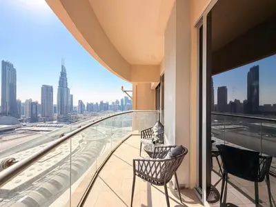 a balcony with two chairs and a view of the city at 1BR Apt Kempinski Central Avenue Downtown Dubai in Dubai