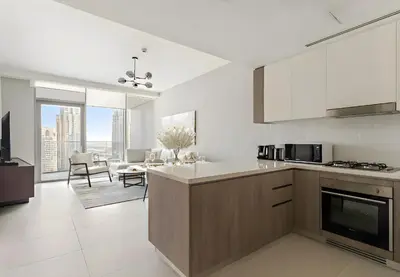 a kitchen with white appliances and a living room at Luxury 1BR in LIV Marina with Canal Views in Dubai