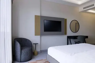 a bedroom with a bed and a chair and a tv at Marriott Executive Apartments Jumeirah Lakes Towers, Dubai in Dubai