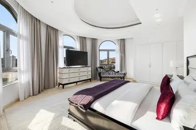 a white bedroom with a large bed and a television at Luxury 5BR plus Maid Private Villa with Direct Beach Access in Dubai