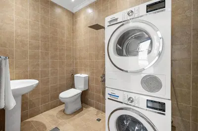 a bathroom with a washing machine and a toilet at Luxury 5BR plus Maid Private Villa with Direct Beach Access in Dubai