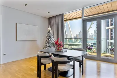 a dining room with a christmas tree and a table at Mira Holiday Homes - Sky High Bliss at Bluewaters Residence 3 Ain View in Dubai