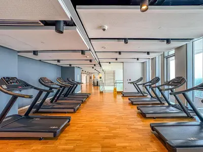 a row of treadmills in a gym with at Mira Holiday Homes - Sky High Bliss at Bluewaters Residence 3 Ain View in Dubai
