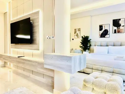 a bedroom with a large bed and a tv at Venduras - Luxe Studio, City Views , Sterling by Omniyat in Dubai