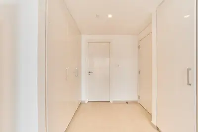 an empty room with white walls and a hallway at Stunning 2BR Skyline Stay With Full Burj Khalifa View in Dubai