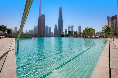 a swimming pool with a city skyline in the background at Stunning 2BR Skyline Stay With Full Burj Khalifa View in Dubai