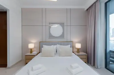 a bedroom with a large white bed with two lamps at Palace Beach Residence 2, Emaar Beachfront - Mint Stay in Dubai