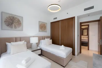 a hotel room with two beds and a desk at Palace Beach Residence 2, Emaar Beachfront - Mint Stay in Dubai