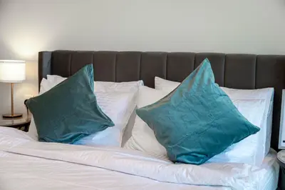 two blue pillows sitting on top of a bed at Dubai Business Bay Luxurious Studio with Canal View and access to Lagoon Pool in Dubai