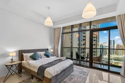 a bedroom with a bed and a large window at Dubai Business Bay Luxurious Studio with Canal View and access to Lagoon Pool in Dubai