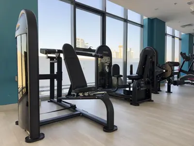 a gym with several tread machines in a room with windows at Meydan Luxury Stylish 2BR with Pool & City Views in Dubai