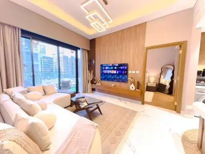 a living room with a white couch and a large window at Meydan Luxury Stylish 2BR with Pool & City Views in Dubai