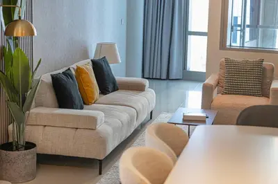 a living room with two couches and a table at StayMada - Ocean Heights Panoramic Beach Views in Dubai
