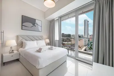 a bedroom with a white bed and a large window at StayMada - Ocean Heights Panoramic Beach Views in Dubai
