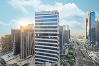 a tall building with a sign on it in a city at StayMada - Peninsula Luxury Apartment with Balcony in Dubai