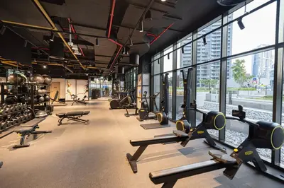 a gym with rows of treadmills and pilates equipment at StayMada - Peninsula Luxury Apartment with Balcony in Dubai