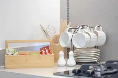 a counter with plates and utensils in a kitchen at VIDA DUBAI MALL - Burj Khalifa Views 2 Bedroom Apartment Opposite Dubai Mall & 5 Minutes Walk To Burj Khalifa and Dubai Fountain by NAMUVE in Dubai