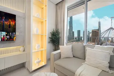 a living room with a couch and a large window at VIDA DUBAI MALL - Burj Khalifa Views 2 Bedroom Apartment Opposite Dubai Mall & 5 Minutes Walk To Burj Khalifa and Dubai Fountain by NAMUVE in Dubai