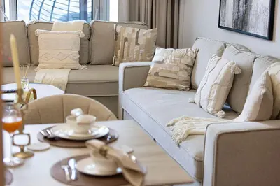 a living room with a couch and a table at VIDA DUBAI MALL - Burj Khalifa Views 2 Bedroom Apartment Opposite Dubai Mall & 5 Minutes Walk To Burj Khalifa and Dubai Fountain by NAMUVE in Dubai