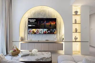 a living room with a tv on a wall at The Burj View Suite by NAMUVE at BLVD Central in Dubai