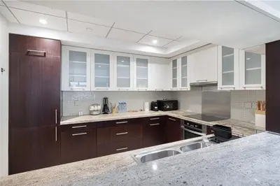 a large kitchen with wooden cabinets and a sink at The Burj View Suite by NAMUVE at BLVD Central in Dubai