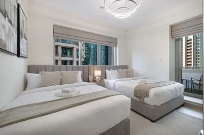 a bedroom with two beds and a large window at The Burj View Suite by NAMUVE at BLVD Central in Dubai