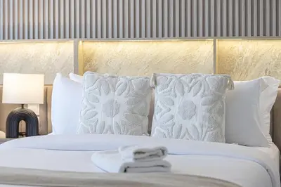 a bedroom with a white bed with white pillows at The Imperial Burj View by NAMUVE at 29 Boulevard in Dubai