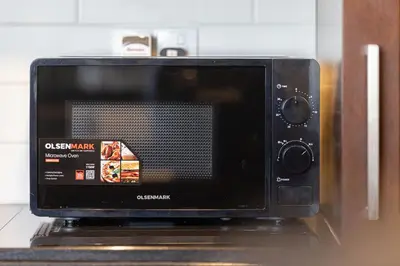 a microwave oven sitting on top of a counter at The Imperial Burj View by NAMUVE at 29 Boulevard in Dubai