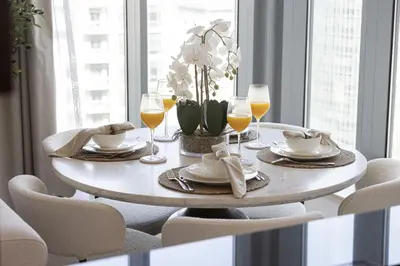 a dining room table with glasses of wine and a table with chairs at The Imperial Burj View by NAMUVE at 29 Boulevard in Dubai