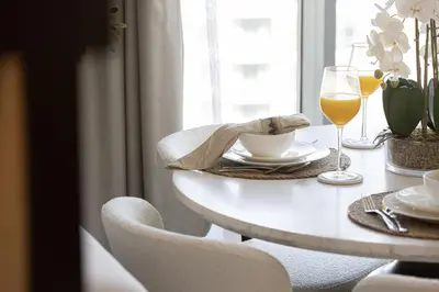 a table with a glass of wine and a table with chairs at The Imperial Burj View by NAMUVE at 29 Boulevard in Dubai