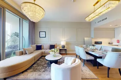 a living room with a couch and a dining room at Locations I Downtown Dubai I Premium 3BR Apartment I Luxury & Modern Interiors I Stunning Burj Khalifa Views I Steps from Dubai Mall & Dubai Fountain in Dubai