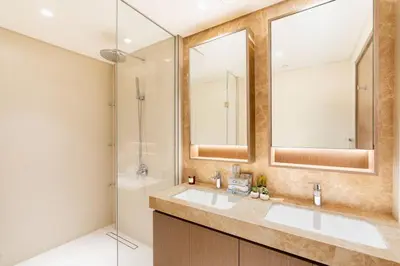 a bathroom with two sinks and a shower at CitiHome - Elie Saab Luxury 2BR - Sea View in Dubai
