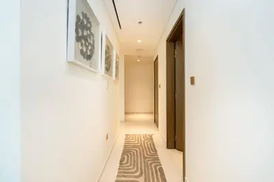 a hallway with white walls and a rug on the floor at CitiHome - Elie Saab Luxury 2BR - Sea View in Dubai