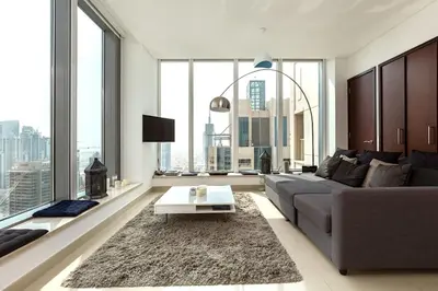 a living room with a couch and a table at Skyline 43 - Penthouse Burj Khalifa View & Pool in Dubai