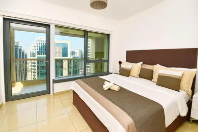 a bedroom with a large bed and large windows at Skyline 43 - Penthouse Burj Khalifa View & Pool in Dubai