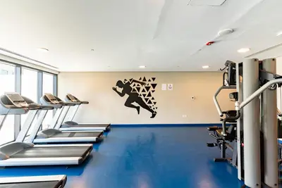 a gym with several treadmills and a wall with a graphic at 1BR with Burj Khalifa view in Business Bay in Dubai