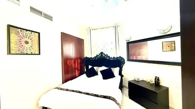 a bedroom with a bed and a dresser and a window at Dubai gate 1 in Dubai
