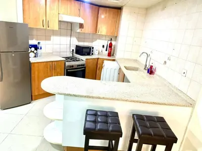a kitchen with a counter with two stools in it at Dubai gate 1 in Dubai