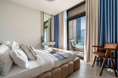 a bedroom with a large bed and a large window at Waterfront 1BR with Canal Views in Peninsula One in Dubai