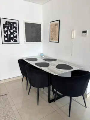 a dining room with a table and black chairs at Modern apartment Dubai in Dubai