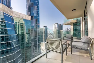 a balcony with a table and chairs and a view of the city at Balcony with Panoramic Dubai Water Canal and City Views, Walking Distance to Metro and Marine Transport, Urban Oasis, Business Bay by Deluxe Holiday Homes in Dubai