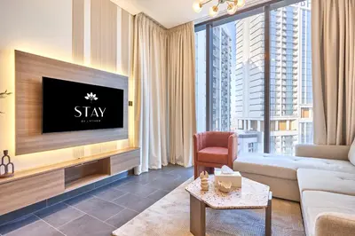 a living room with a tv and a couch at STAY BY LATINEM Luxury 1BR Holiday Home CC 2913 Near Burj Khalifa in Dubai