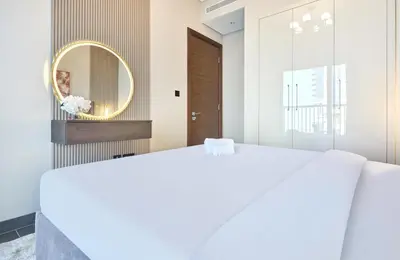 a bedroom with a large white bed and a mirror at STAY BY LATINEM Luxury 1BR Holiday Home CC 2913 Near Burj Khalifa in Dubai