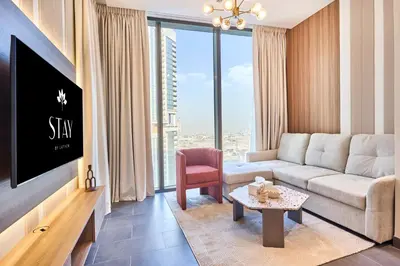 a living room with a couch and a tv at STAY BY LATINEM Luxury 1BR Holiday Home CC 2913 Near Burj Khalifa in Dubai