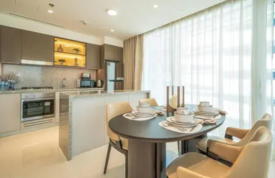 a dining room with a table and chairs in a kitchen at Zapbed House -Elegant 1 BR Apartment Grand Bleu Emaar Beachfront in Dubai